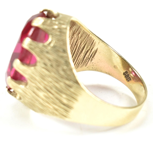 40A - A 1970s 14ct gold and synthetic ruby ring. The ring having a large claw mounted oval mixed cut synth... 