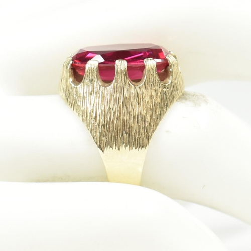 40A - A 1970s 14ct gold and synthetic ruby ring. The ring having a large claw mounted oval mixed cut synth... 