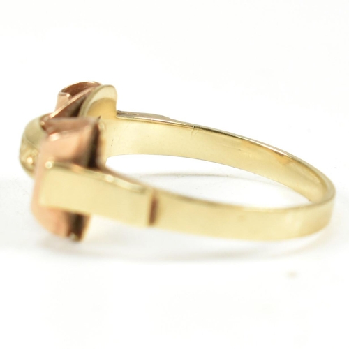 45A - A 14ct gold retro ring. The ring having a scrolled and etched decorated bi colour gold head to plain... 