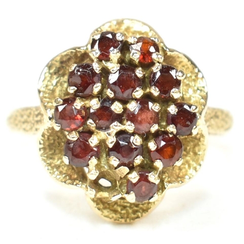 58A - A hallmarked 9ct gold and garnet cluster ring. The ring set with a cluster of round mixed cut garnet... 