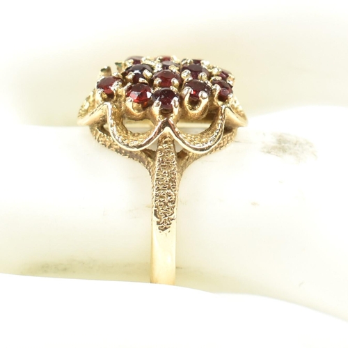 58A - A hallmarked 9ct gold and garnet cluster ring. The ring set with a cluster of round mixed cut garnet... 