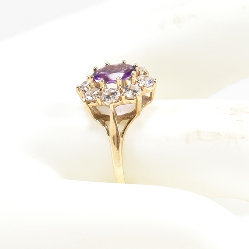 87 - A hallmarked 9ct gold, amethyst and white stone cluster ring. The ring having a central oval cut ame... 