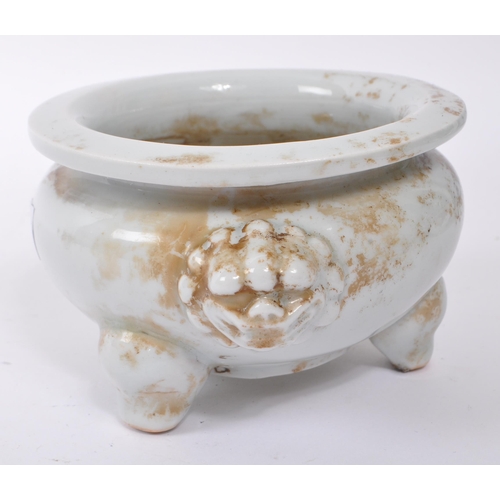 100 - A small 20th Century Chinese white porcelain censer bowl of squat form upon three legs having dragon... 