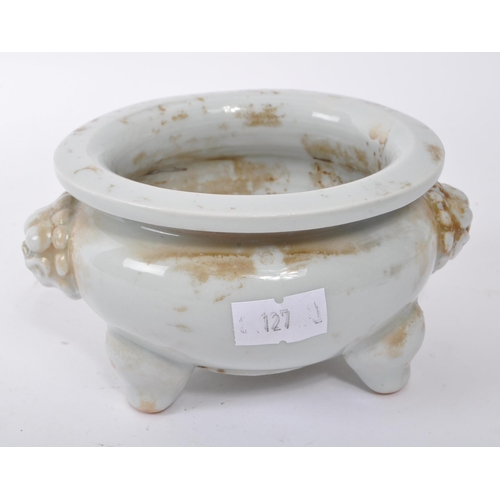 100 - A small 20th Century Chinese white porcelain censer bowl of squat form upon three legs having dragon... 