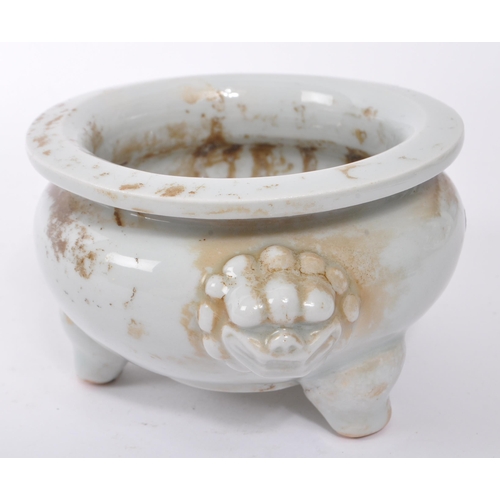 100 - A small 20th Century Chinese white porcelain censer bowl of squat form upon three legs having dragon... 