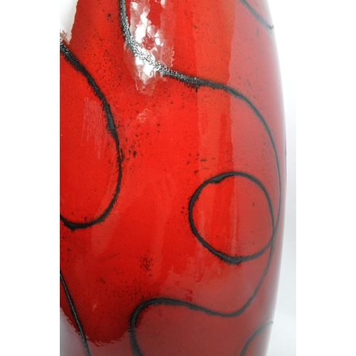 101 - A large ceramic contemporary mottled glazed red vase tapering to top having organic fine black swirl... 