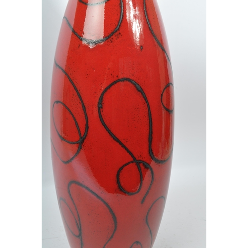 101 - A large ceramic contemporary mottled glazed red vase tapering to top having organic fine black swirl... 