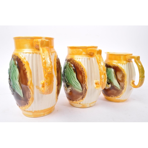 135 - A collection of three 19th Century Victorian ceramic graduating majolica  pitcher jugs George Jones ... 