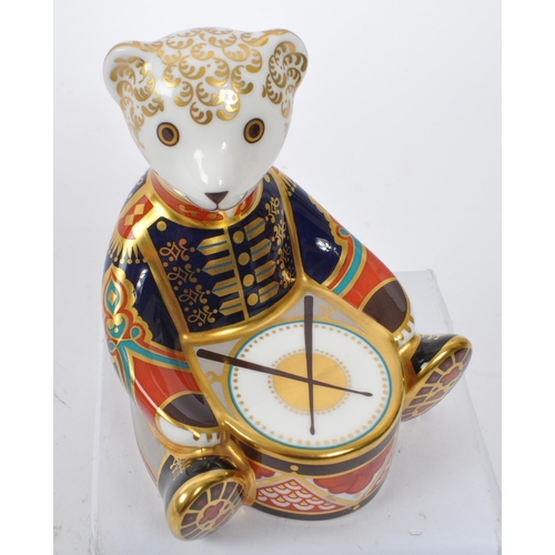 154 - Royal Crown Derby - A china porcelain ' Drummer Teddy ' paperweight in the form of a teddy bear sat ... 