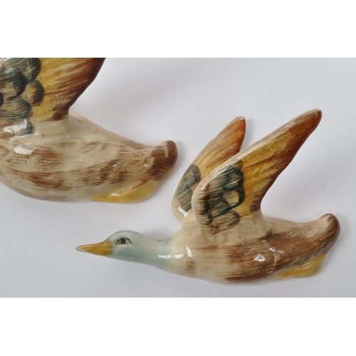 188 - A collection of three ceramic graduating wall hanging Beswick style figures in the form of birds / d... 