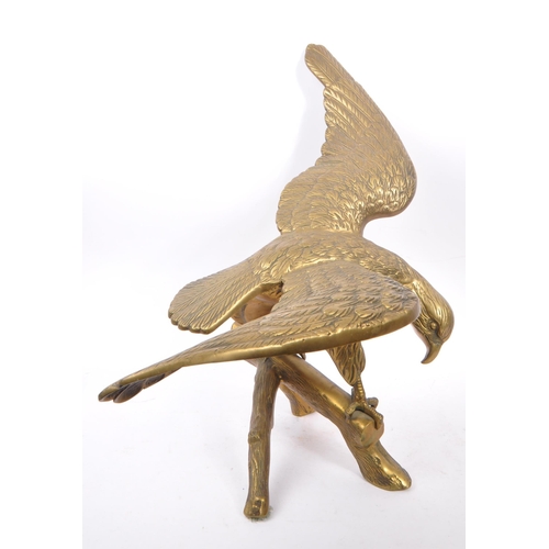 207 - A large brass figure in the form of an eagle with wings spread perched on a branch. Measuring approx... 