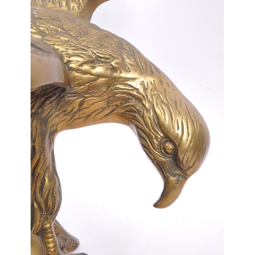 207 - A large brass figure in the form of an eagle with wings spread perched on a branch. Measuring approx... 