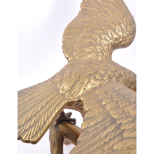 207 - A large brass figure in the form of an eagle with wings spread perched on a branch. Measuring approx... 