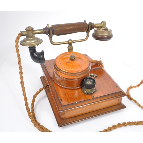 228 - An early 20th century candlestick upright telephone. With metal ring dial with receiver on a holder ... 