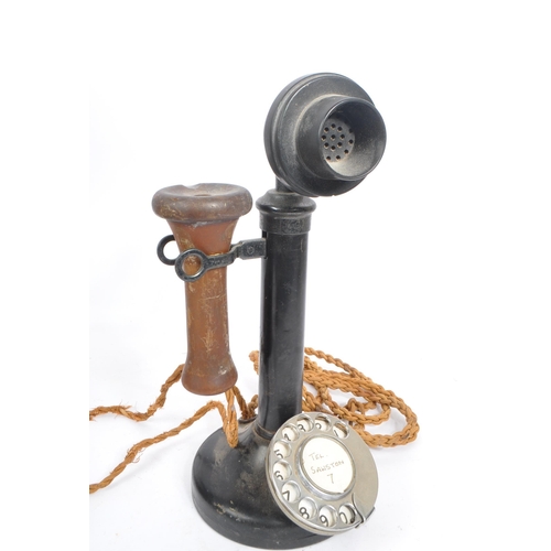 228 - An early 20th century candlestick upright telephone. With metal ring dial with receiver on a holder ... 