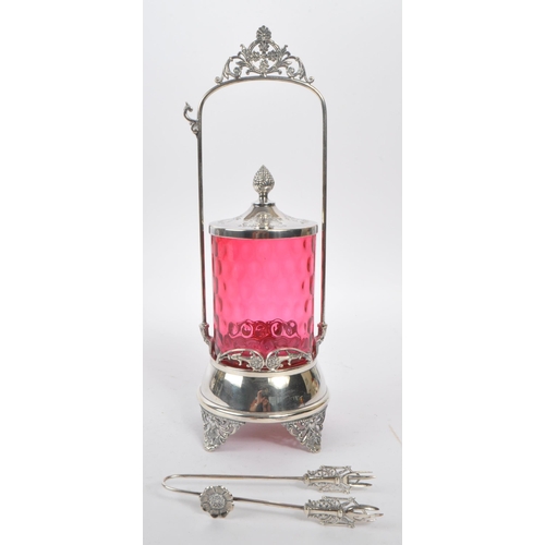 230 - A 19th century Victorian silver tone metal and cranberry glass pickle castor decanter. The castor ra... 