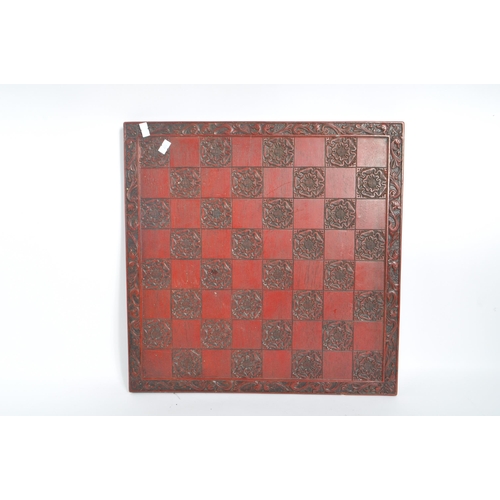 241 - A mid 20th century circa 1960s Chinese red lacquered wooden chess board. The chess board featuring a... 