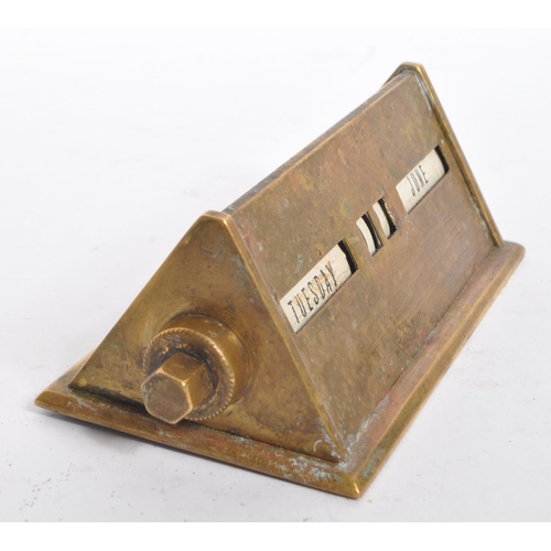 247 - A mid 20th century brass perpetual calendar. The calendar of elongated triangular form, featuring da... 