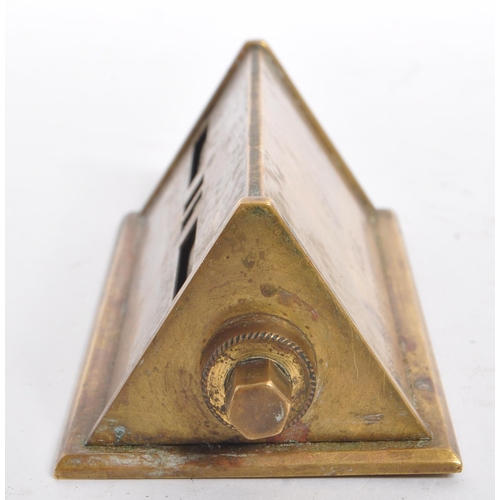 247 - A mid 20th century brass perpetual calendar. The calendar of elongated triangular form, featuring da... 