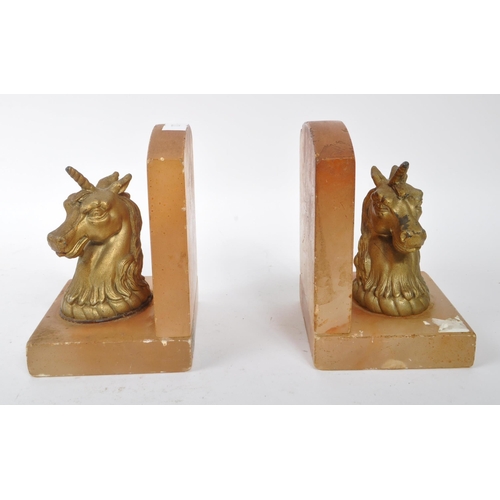 249 - A pair of mid 20th century alabaster unicorn bookends. The bookends featuring gilt unicorn busts to ... 