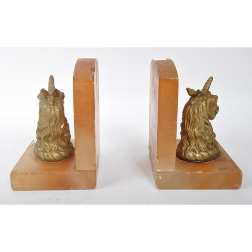 249 - A pair of mid 20th century alabaster unicorn bookends. The bookends featuring gilt unicorn busts to ... 