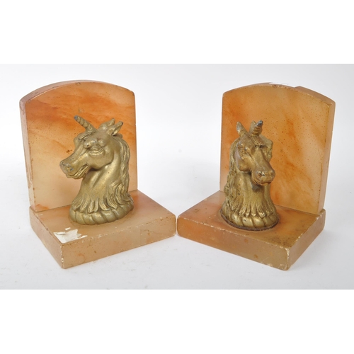 249 - A pair of mid 20th century alabaster unicorn bookends. The bookends featuring gilt unicorn busts to ... 