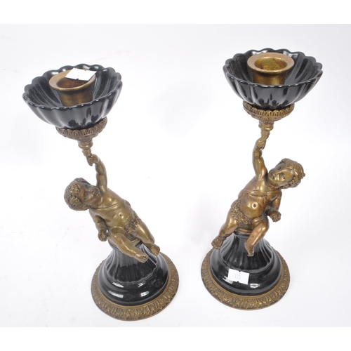 250 - A pair of early 20th century French Putto / Putti brass and ceramic candlesticks. The candlesticks f... 