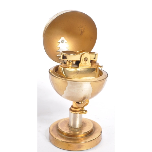 254 - A 20th century desktop gilt metal globe clock and table lighter. Each piece raised on a round steppe... 