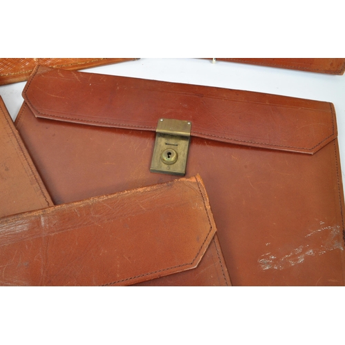 264 - A collection of vintage leather document / folio cases carriers to include tooled example with brass... 