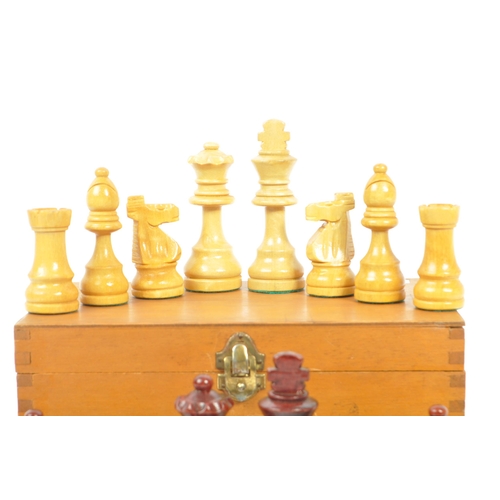 290 - A vintage 20th century beech wood chess set. The chess set featuring red and white pieces, with all ... 