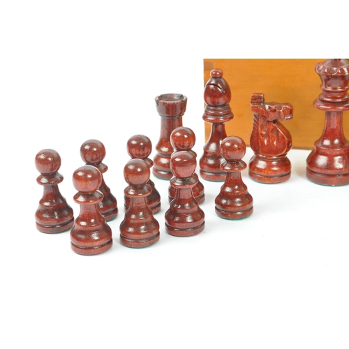 290 - A vintage 20th century beech wood chess set. The chess set featuring red and white pieces, with all ... 