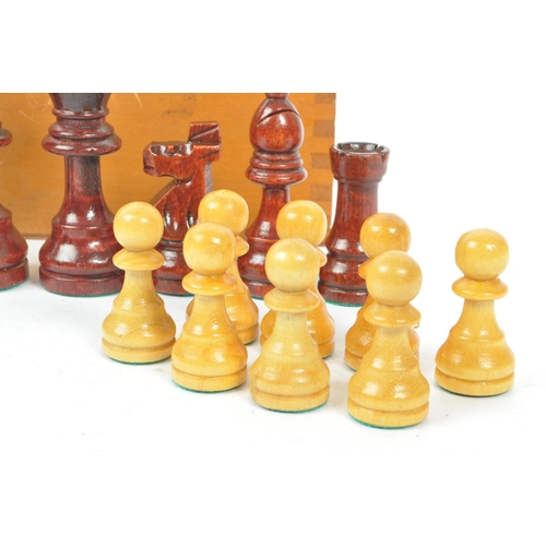 290 - A vintage 20th century beech wood chess set. The chess set featuring red and white pieces, with all ... 