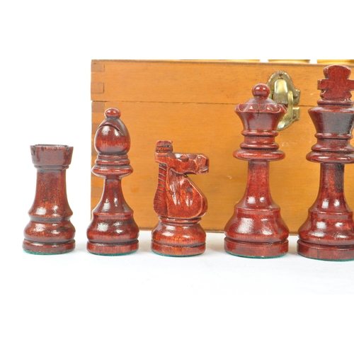 290 - A vintage 20th century beech wood chess set. The chess set featuring red and white pieces, with all ... 