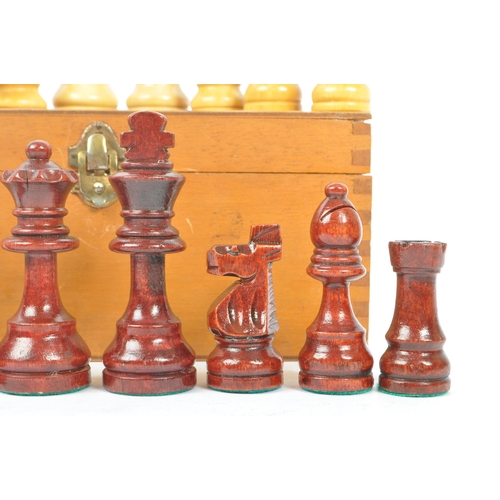 290 - A vintage 20th century beech wood chess set. The chess set featuring red and white pieces, with all ... 