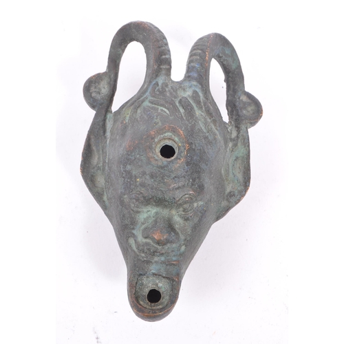 292 - A bronze Roman style oil lamp in the form of a faun / devil face with pointed ears and large curved ... 