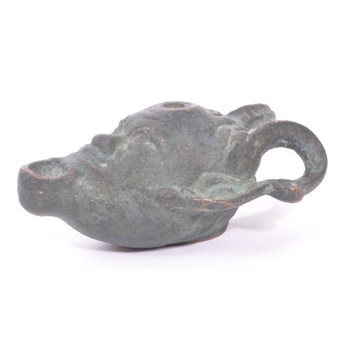 292 - A bronze Roman style oil lamp in the form of a faun / devil face with pointed ears and large curved ... 