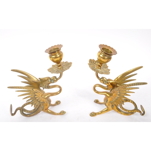 294 - A collection of four brass candlesticks comprising of a 19th Century pair in the form of crouching p... 