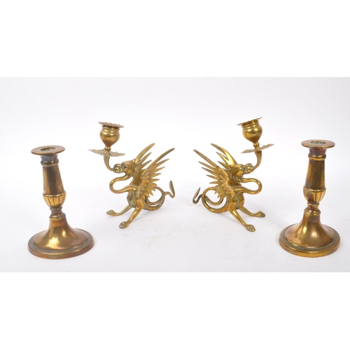 294 - A collection of four brass candlesticks comprising of a 19th Century pair in the form of crouching p... 