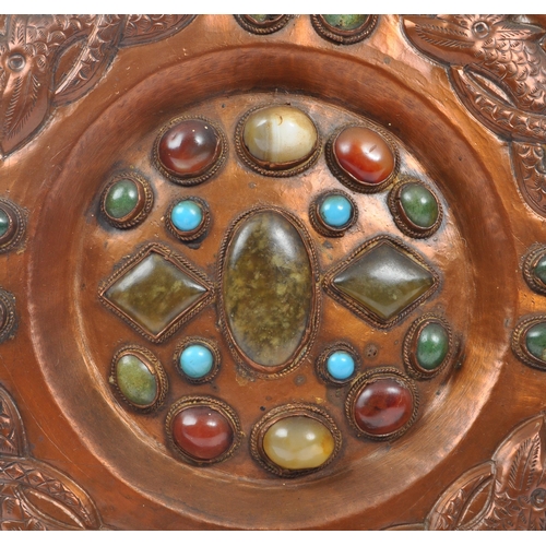 302 - A 20th century Moorish wedding copper wall charger plate inset with various polished gemstones with ... 