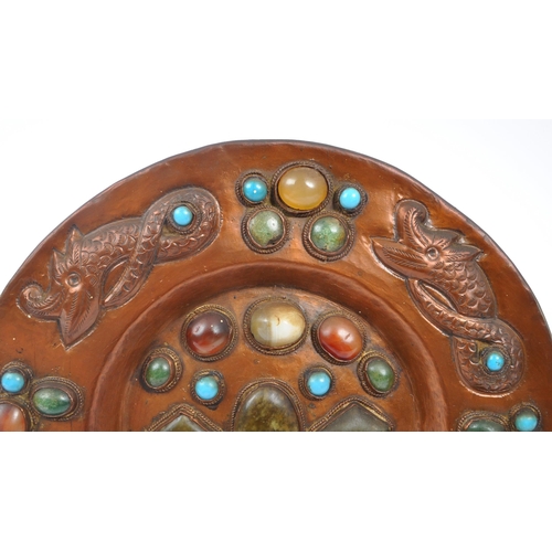 302 - A 20th century Moorish wedding copper wall charger plate inset with various polished gemstones with ... 