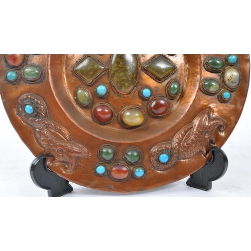 302 - A 20th century Moorish wedding copper wall charger plate inset with various polished gemstones with ... 