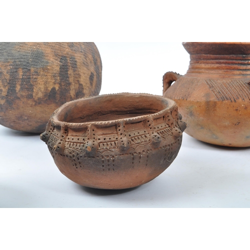 31 - A collection of clay East African Kenyan pottery pots. Some examples with textured bodies with raise... 