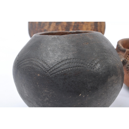 31 - A collection of clay East African Kenyan pottery pots. Some examples with textured bodies with raise... 