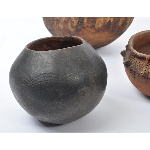 31 - A collection of clay East African Kenyan pottery pots. Some examples with textured bodies with raise... 