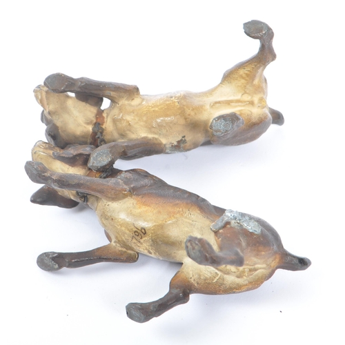 314 - A hollow bronze figurine in the form of two dogs / hounds attached together by chain, both standing ... 