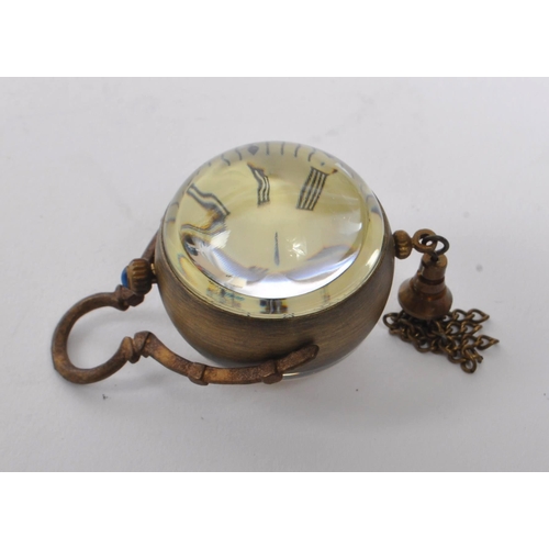 351 - A small 20th Century brass cased desk style ball clock / orb pocket watch of spherical form with bla... 