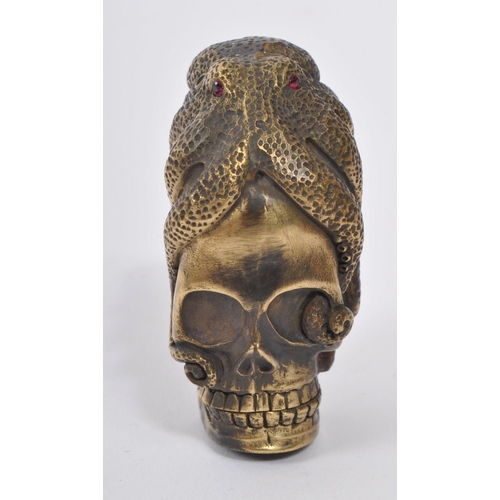 358 - A 20th Century brass vesta case in the form of a skull covered by an octopus with red stone eyes. En... 