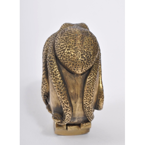 358 - A 20th Century brass vesta case in the form of a skull covered by an octopus with red stone eyes. En... 