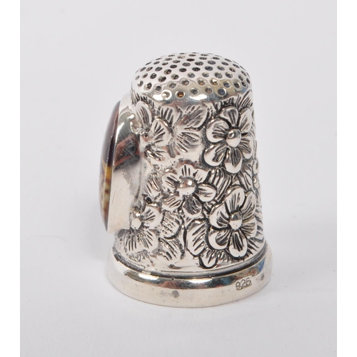 361 - A 20th Century vintage .925 sterling silver thimble with floral decoration and having an oval cameo ... 