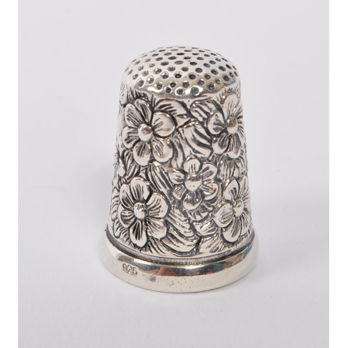 361 - A 20th Century vintage .925 sterling silver thimble with floral decoration and having an oval cameo ... 